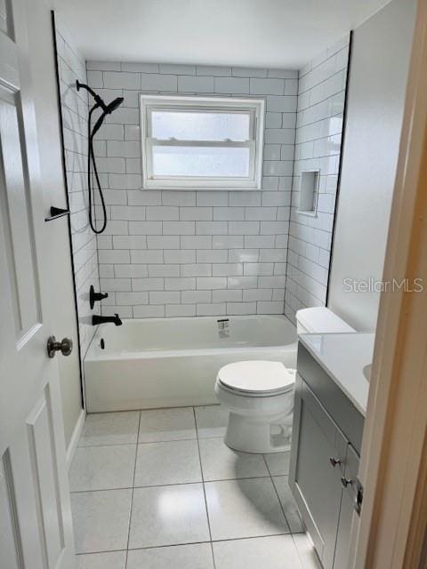 full bathroom featuring toilet, vanity, tile patterned flooring, and tiled shower / bath