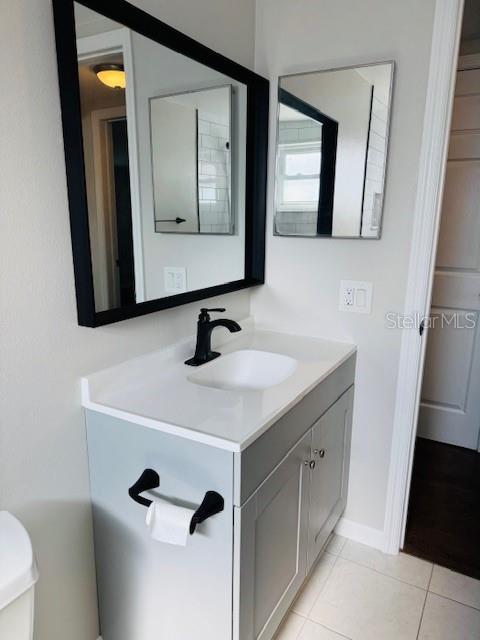 bathroom featuring toilet, tile patterned flooring, and vanity