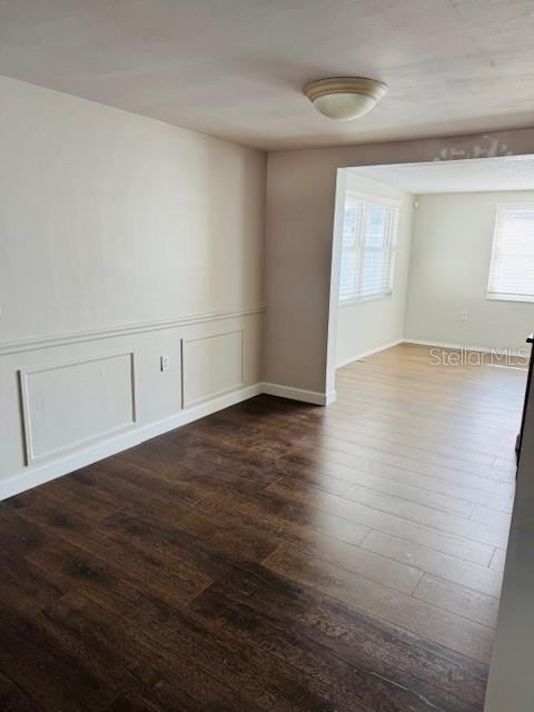 empty room with dark wood-type flooring