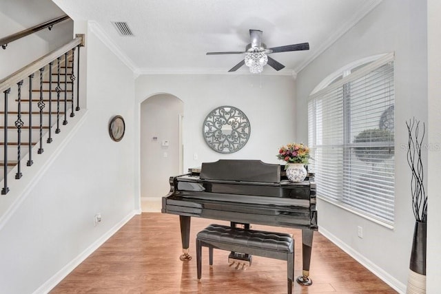 miscellaneous room featuring ceiling fan, wood-type flooring, and ornamental molding