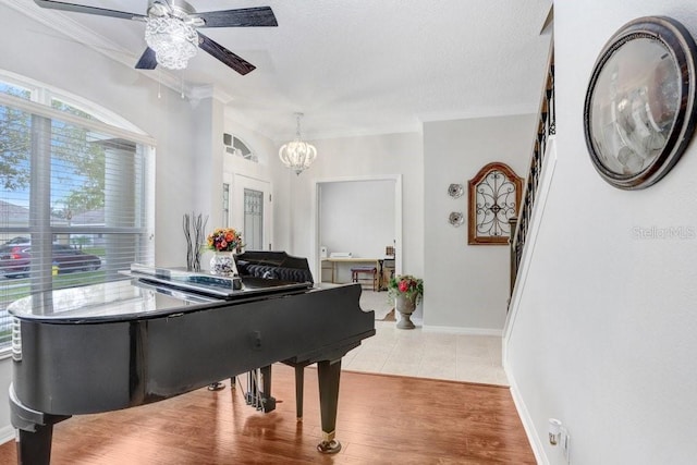 miscellaneous room featuring light tile patterned floors, ceiling fan with notable chandelier, and crown molding