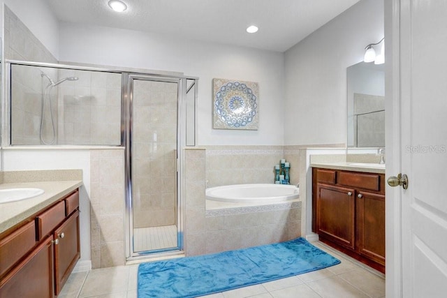 bathroom featuring independent shower and bath, tile patterned flooring, and vanity