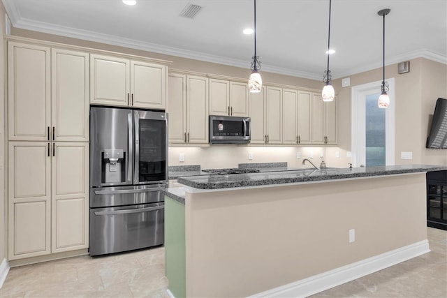 kitchen featuring stainless steel appliances, pendant lighting, dark stone counters, and cream cabinetry