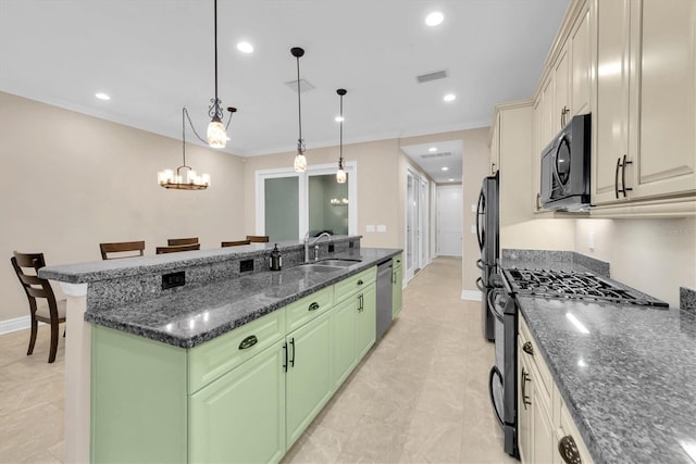 kitchen with range with gas stovetop, dark stone counters, a breakfast bar, and pendant lighting