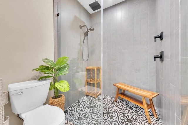 bathroom featuring a tile shower and toilet