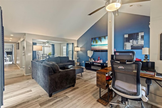 living room with ceiling fan, vaulted ceiling, and light hardwood / wood-style flooring