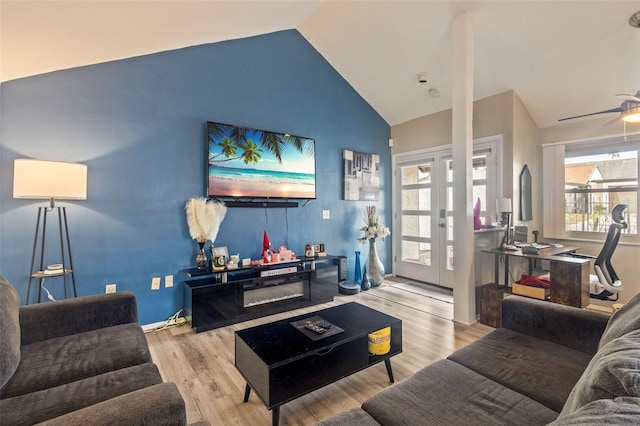 living room featuring lofted ceiling, ceiling fan, plenty of natural light, and light hardwood / wood-style flooring