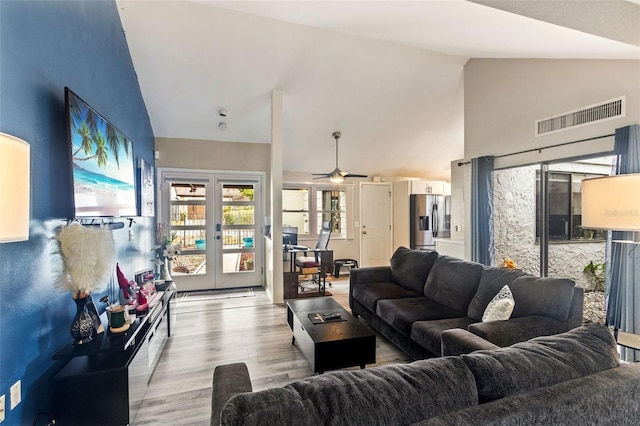 living room with ceiling fan, french doors, high vaulted ceiling, and light hardwood / wood-style floors