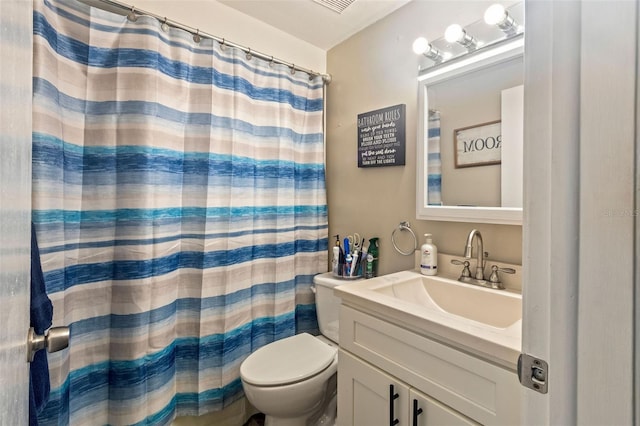 bathroom with toilet, vanity, and walk in shower