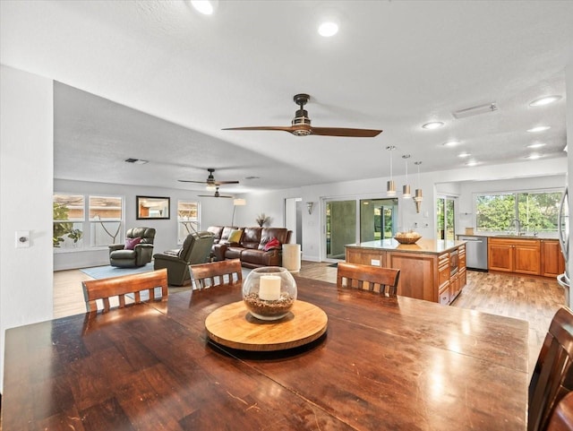 dining room featuring light wood-type flooring, ceiling fan, a textured ceiling, and sink