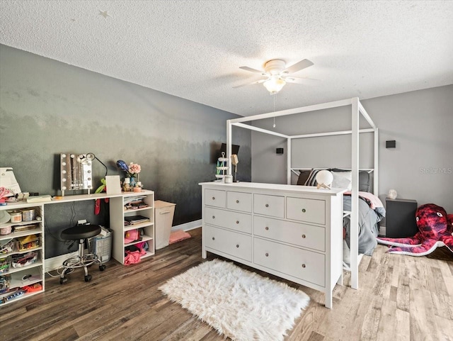 bedroom with ceiling fan, hardwood / wood-style floors, and a textured ceiling