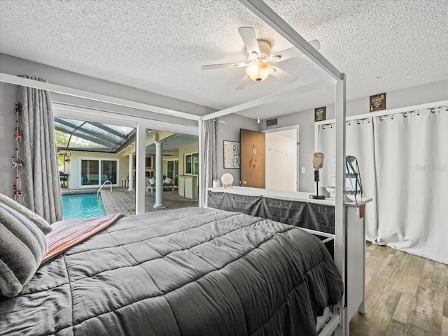 bedroom featuring access to outside, hardwood / wood-style flooring, a textured ceiling, and ceiling fan