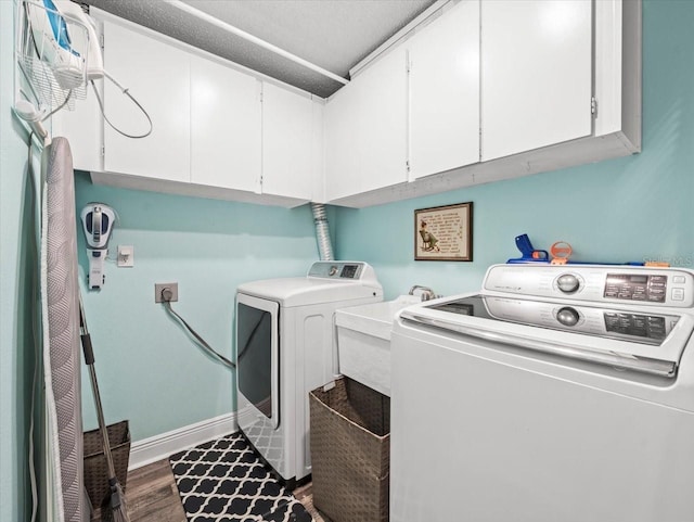 washroom with washing machine and dryer, dark wood-type flooring, and cabinets