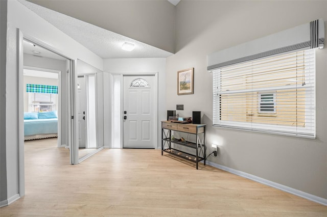 entryway featuring light wood-type flooring and a textured ceiling