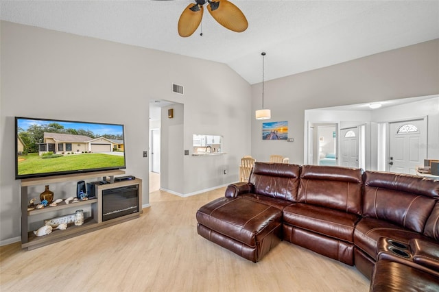 living room with light wood-type flooring, vaulted ceiling, and ceiling fan