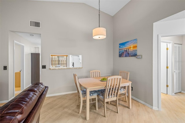 dining area with vaulted ceiling and light hardwood / wood-style flooring