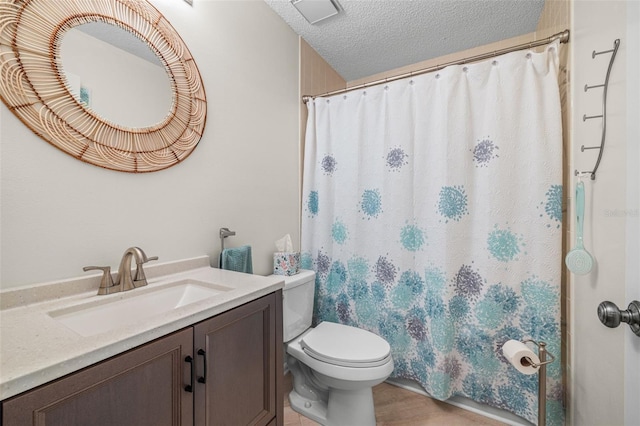 bathroom with toilet, vanity, and a textured ceiling