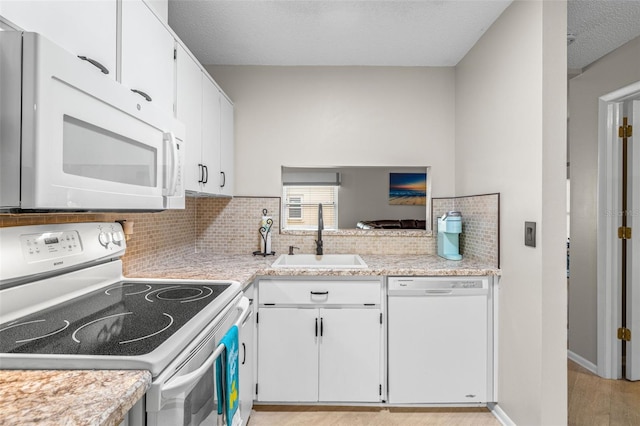 kitchen with white cabinetry, sink, white appliances, and backsplash