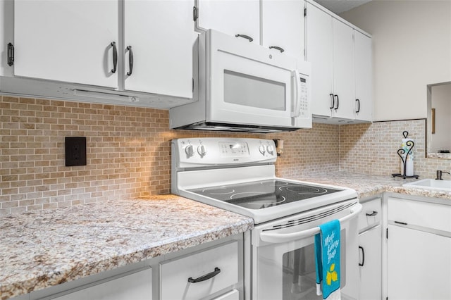 kitchen featuring white cabinetry, sink, tasteful backsplash, and white appliances