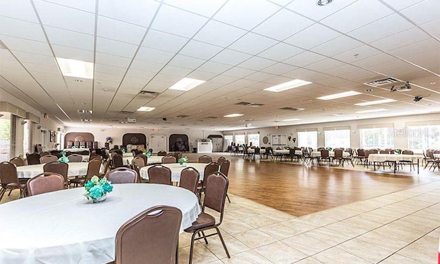 dining area featuring a paneled ceiling and light tile patterned floors