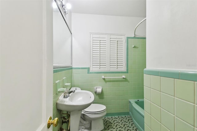 bathroom with toilet, tile patterned flooring, tile walls, and  shower combination