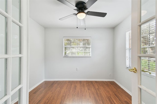 spare room with dark wood-type flooring and ceiling fan