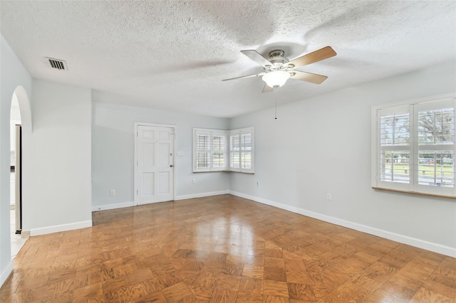 spare room with parquet flooring, a textured ceiling, and ceiling fan