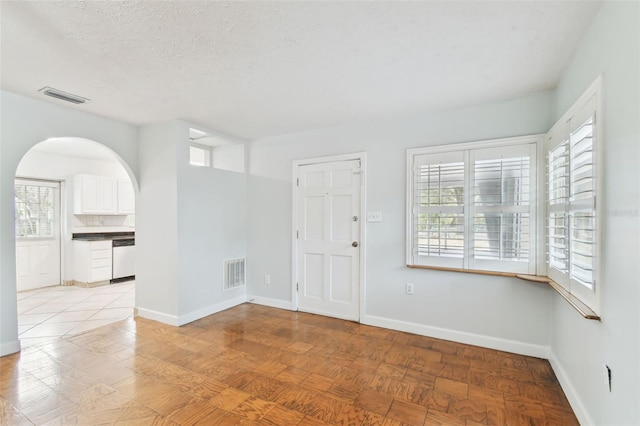 unfurnished room featuring a textured ceiling