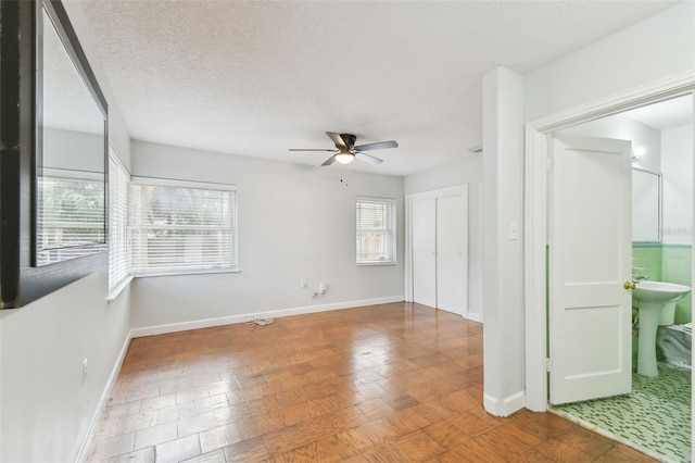 unfurnished room with a textured ceiling and ceiling fan