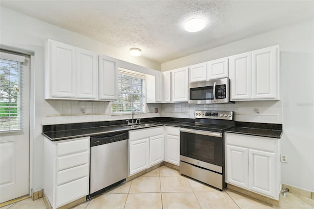 kitchen featuring sink, stainless steel appliances, white cabinetry, and a textured ceiling