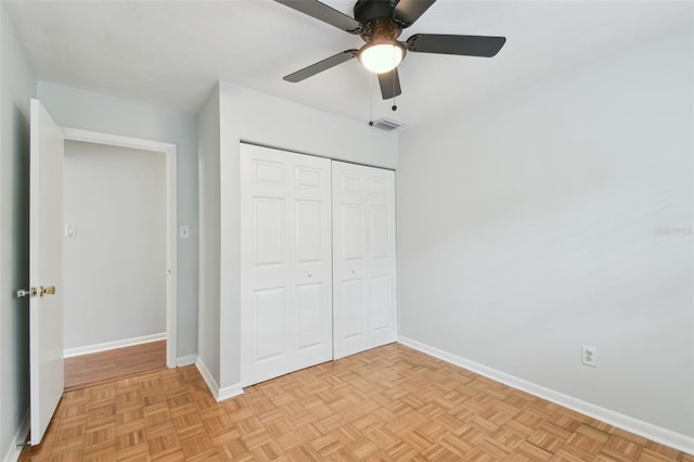 unfurnished bedroom featuring a closet, light parquet flooring, and ceiling fan