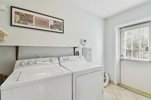 laundry room featuring washer and clothes dryer and light tile patterned flooring