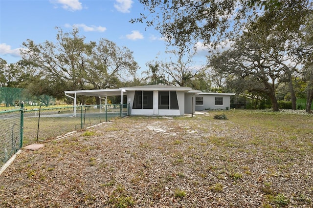 rear view of property with a carport and a sunroom