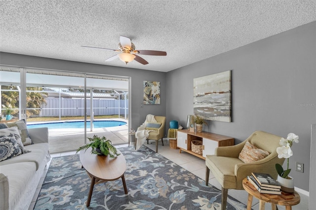 tiled living room featuring ceiling fan and a textured ceiling