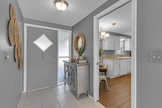 tiled entrance foyer featuring sink and a textured ceiling