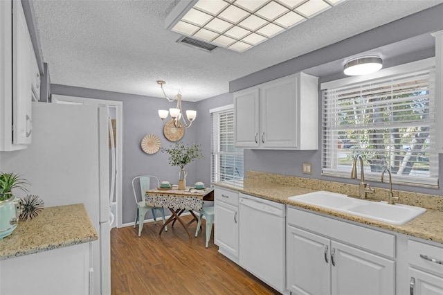 kitchen with pendant lighting, sink, light wood-type flooring, white cabinets, and white appliances