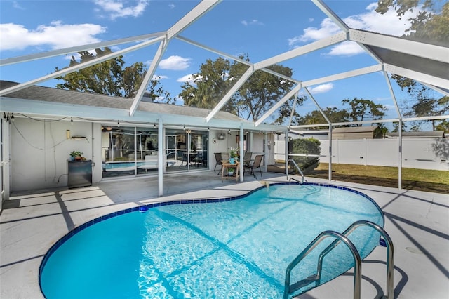 view of pool with a patio and glass enclosure