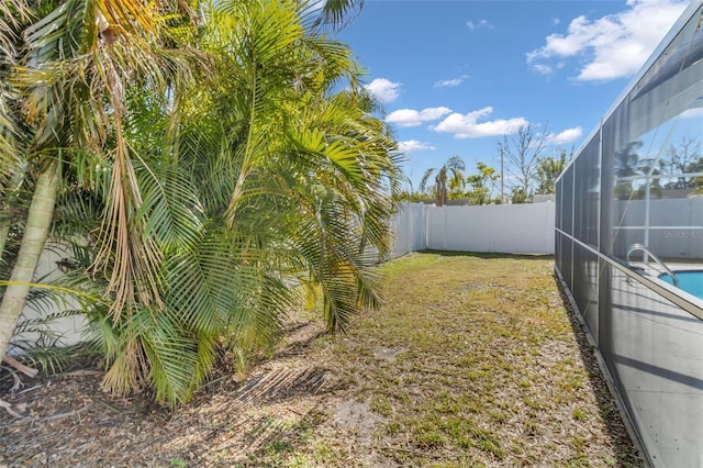 view of yard with a fenced in pool and a lanai