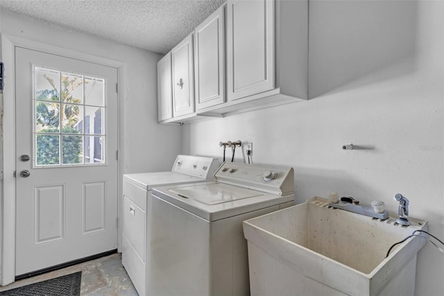 washroom featuring cabinets, separate washer and dryer, sink, and a textured ceiling