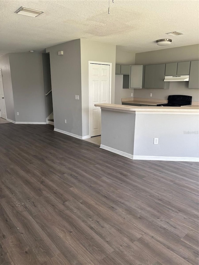 kitchen featuring gray cabinetry, dark hardwood / wood-style floors, a textured ceiling, and black / electric stove