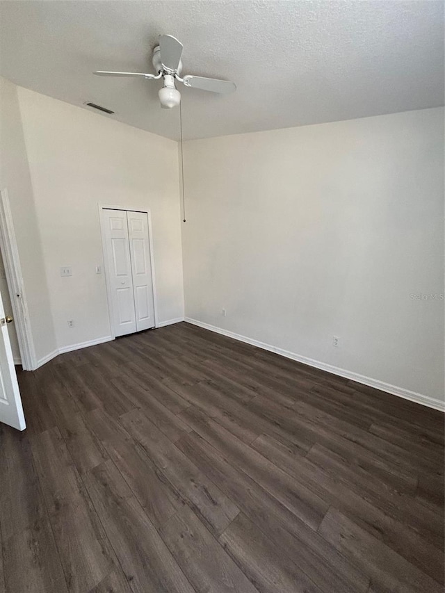 empty room with ceiling fan and dark hardwood / wood-style floors