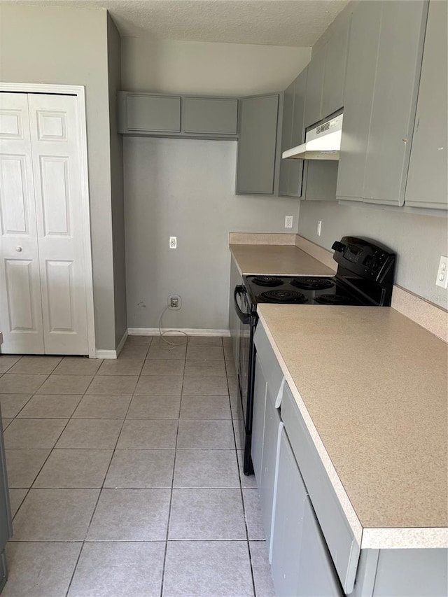 kitchen featuring black range with electric stovetop, gray cabinets, a textured ceiling, and light tile patterned floors