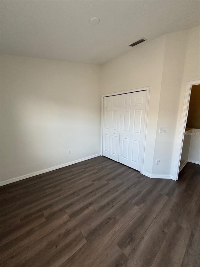 unfurnished bedroom with a closet and dark wood-type flooring