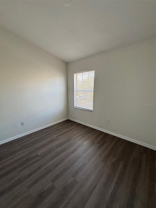 unfurnished room with dark wood-type flooring