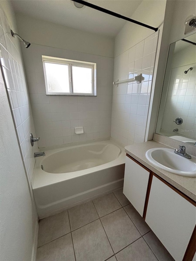 bathroom with tile patterned flooring, tiled shower / bath combo, and vanity