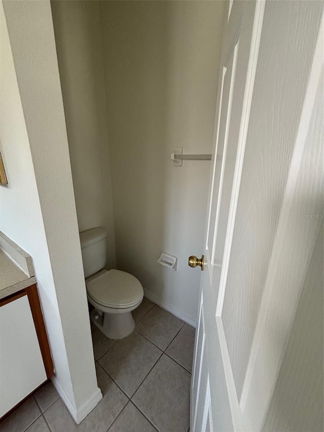 bathroom with toilet and tile patterned flooring