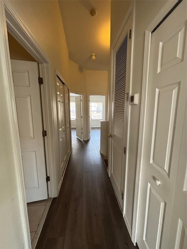 hall featuring a textured ceiling and dark hardwood / wood-style flooring