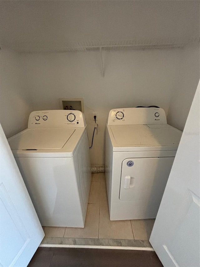 laundry area featuring dark tile patterned flooring and washer and clothes dryer