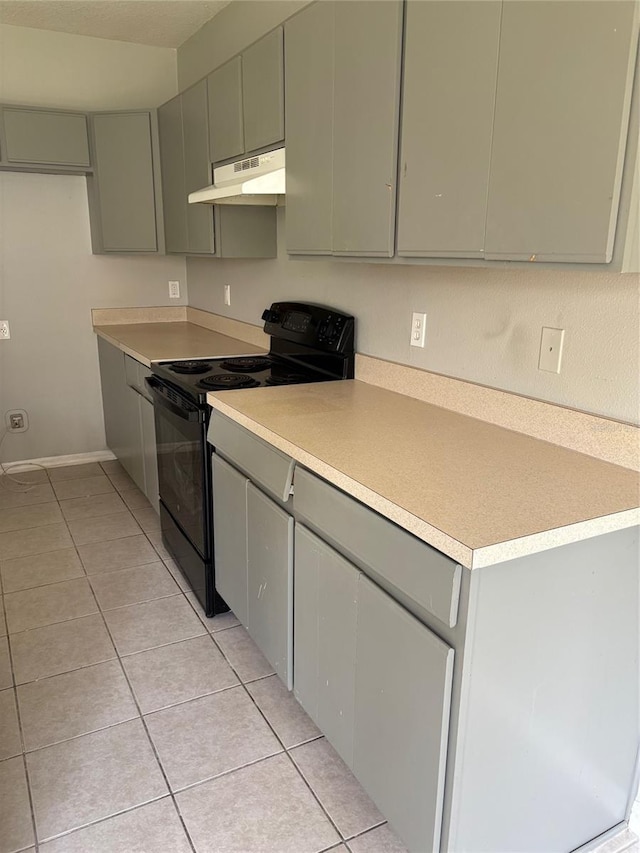 kitchen with black / electric stove and light tile patterned floors