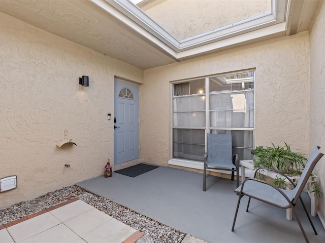 property entrance with a patio area and stucco siding